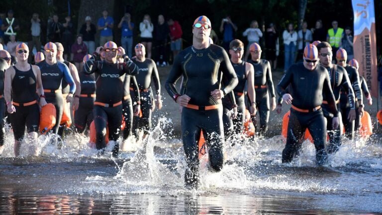 Swimmers running into water